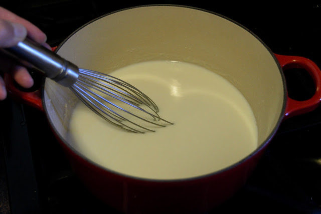 The pot with the roux and milk in it, being whisked to make a sauce.