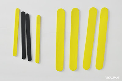 yellow and black craft sticks on a white background