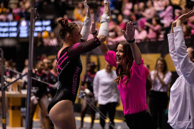 Gymnast and coach smiling and high-fiving