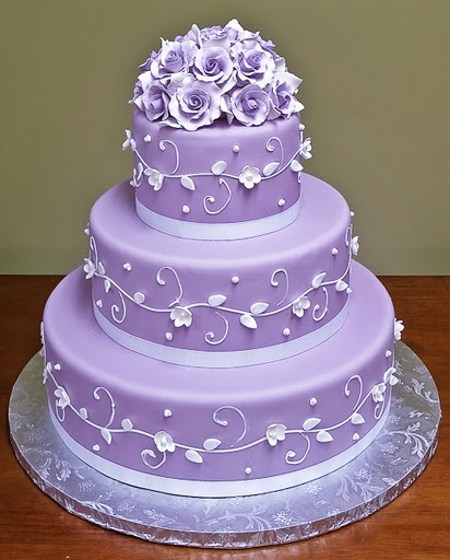 Four tier purple wedding cake with pink blossoms