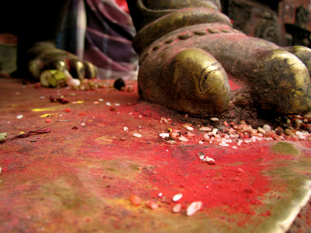 Neon powder and rice at the claws of a figures in Durbar Square.