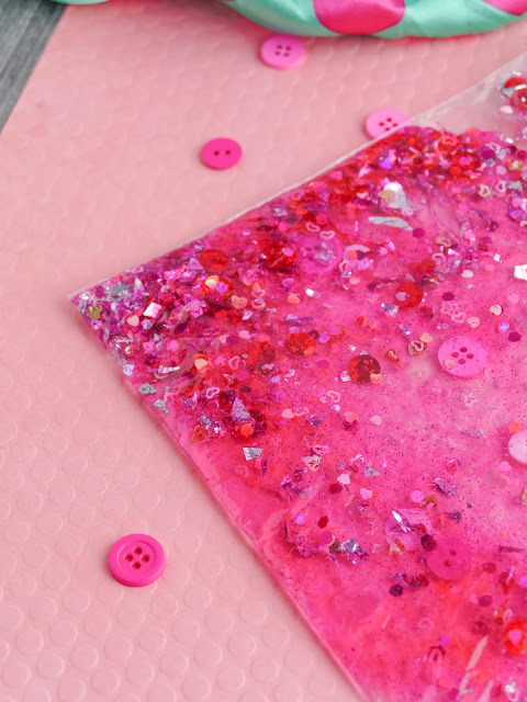 corner of sensory bag on a pink background with pink buttons on the side.