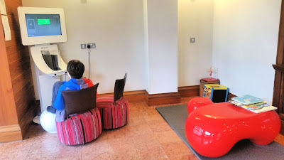 The children's games area, featuring an Xbox station, a box with toys and red table with books on.