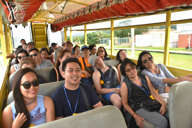 group of people sitting inside vehicle, orange life jackets at the top