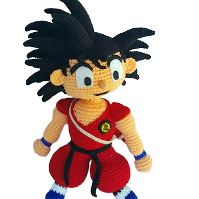 Handmade crochet Goku amigurumi doll with spiky black hair, red outfit, and detailed anime-inspired features for collectors and fans.