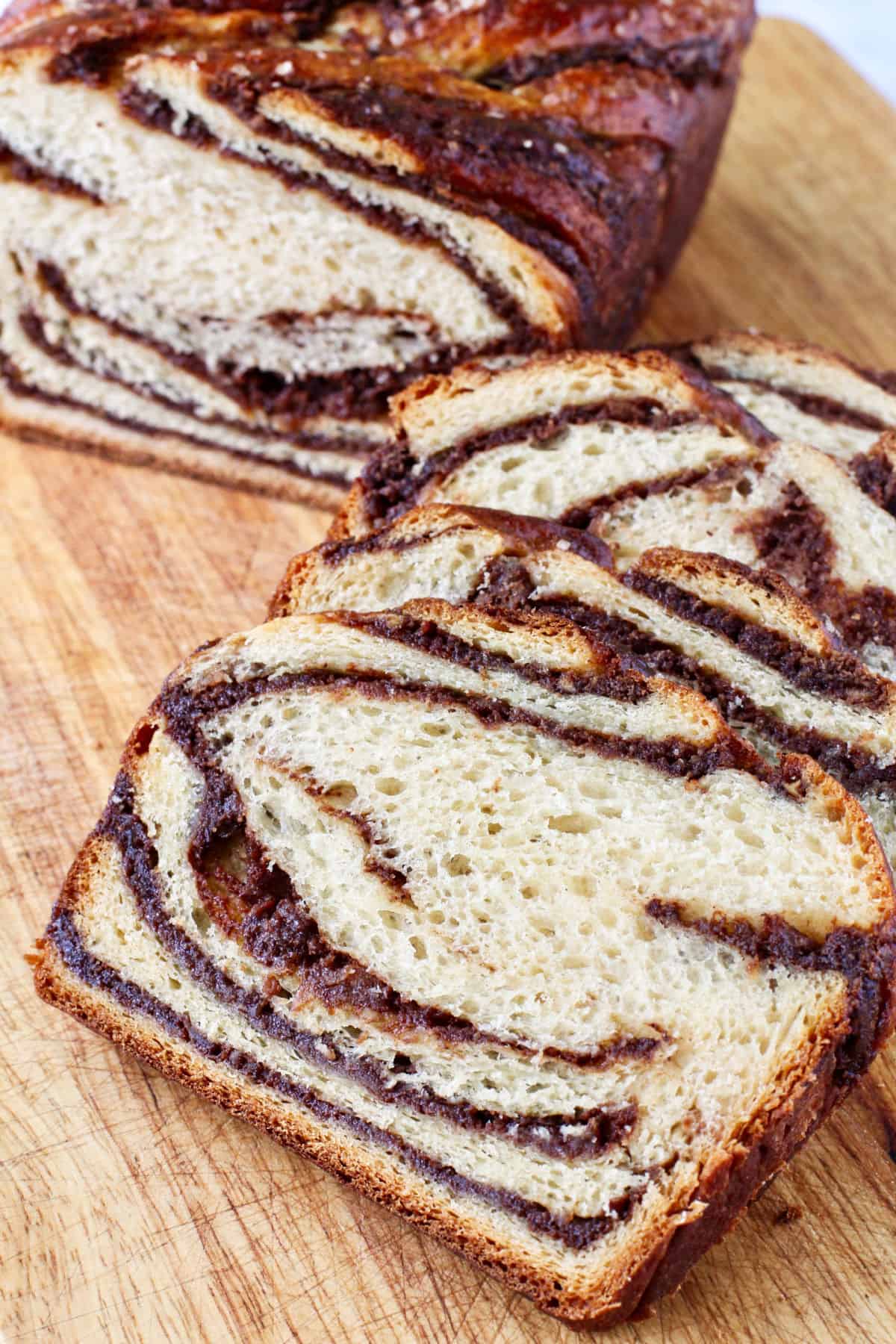 Apple Babka on a cutting board with slices showing the crumb and filling swirls.