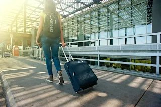 Photo by Oleksandr P: https://www.pexels.com/photo/woman-walking-on-pathway-while-strolling-luggage-1008155/