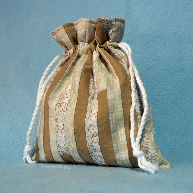 Learn how to make a small, reusable, lined drawstring gift bag. Tutorial by Threading My Way