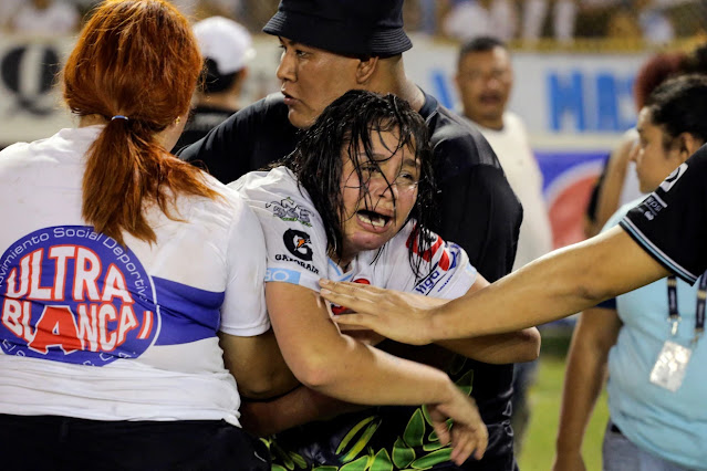 A woman cries following a stampede during a football match between Alianza and FAS at Cuscatlan stadium in San Salvador, El Salvador, on May 20, 2023