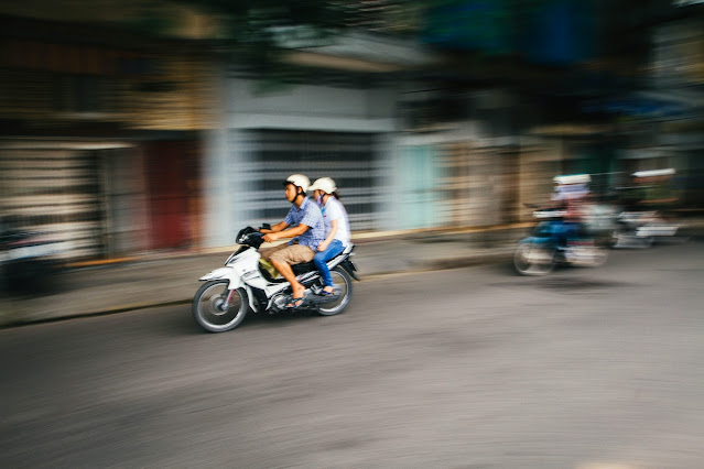 two person riding a scooter