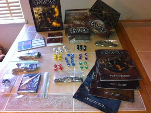 [Image: The Warhammer Fantasy Roleplay kit, splayed out across my table like a train wreck. Contains four books; scads of cards for skills, abilities, insanities, professions, and conditions; stand-ups for the included professions, and 36 custom dice. That is a lot of stuff to pack into a game that can only accommodate three players at a time without buying an expansion.]