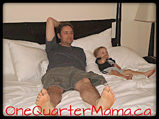 Dada and Little Man lying on hotel room bed on www.onequartermama.ca