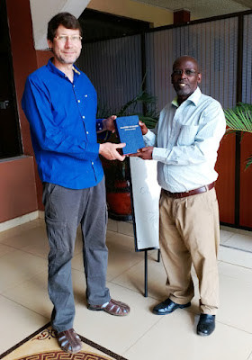 Elder Kihara gifting Tony Suckla a copy of the Sacred Name Swahili Bible.