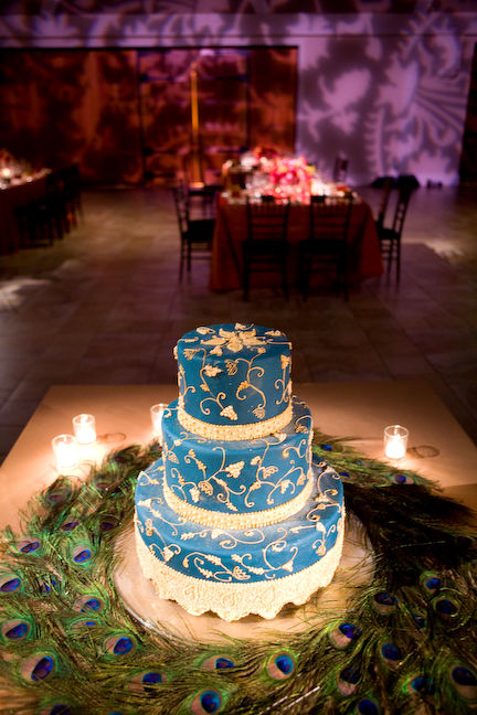Blue wedding cake set over three tiers surrounded by beautiful peacock