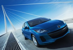 Front 3/4 view of blue Mazda 3 crossing bridge