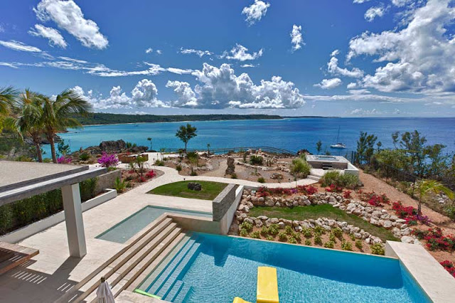 Ocean, swimming pool and the backyard as seen from the modern villa