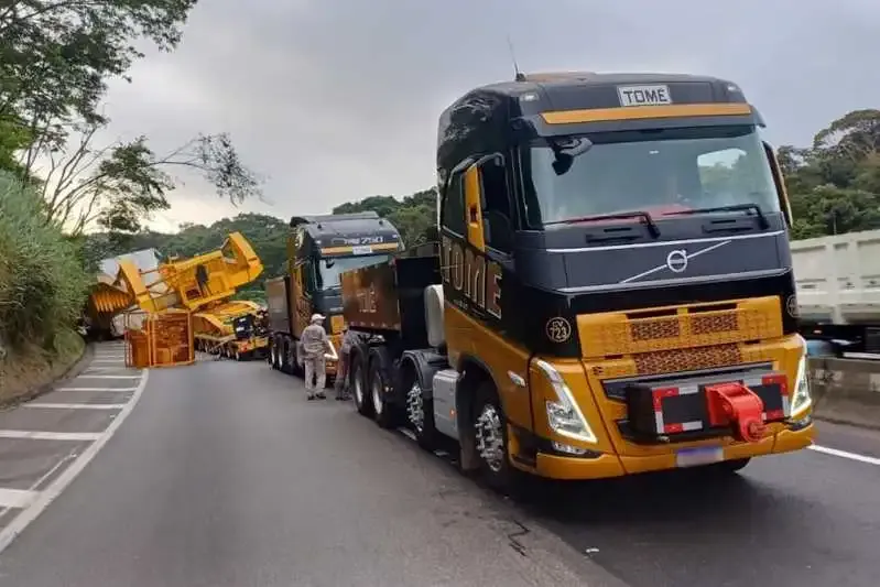 Dois caminhões Volvo FH com linha de eixo com transformador tombado sobre a Via Dutra