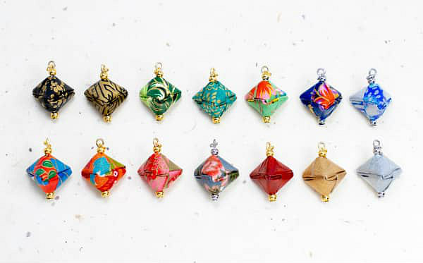 14 examples of colorful origami jewelry beads, each made with a different paper