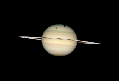 Four moons of Saturn passing in front of their parent planet