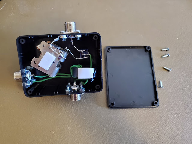 The inside of the HF-319 tuning box has the lower UHF connector soldered to a green wire that loops around a ferrite toroid. The switch connects the side UHF connectors in series/parallel with the air variable tuning capacitor that dominates the space inside the box.