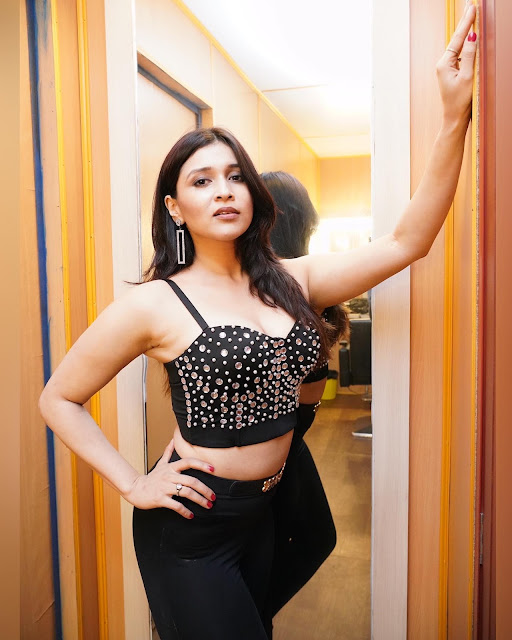 Mannara Chopra exudes glamour in a spaghetti strap blouse and pants, showcasing sensual sophistication.