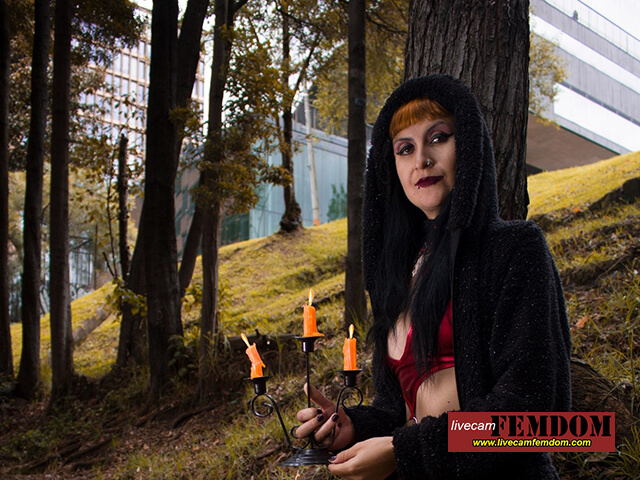 Dominatrix with red hair on livecamfemdom has candles