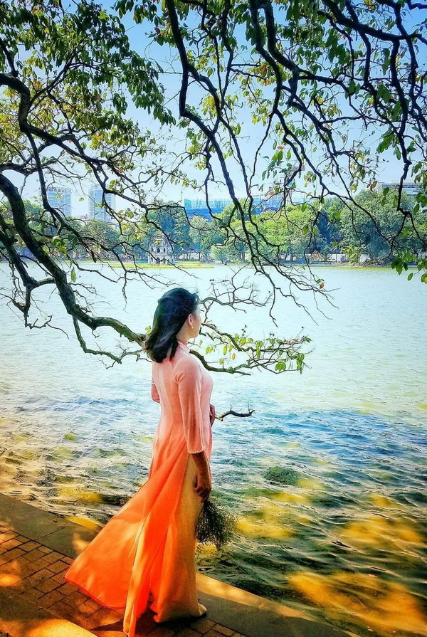 Thiếu nữ áo dài cam bên hồ Gươm