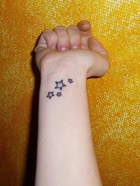 chica con tatuajes de estrellas femeninos y delicados