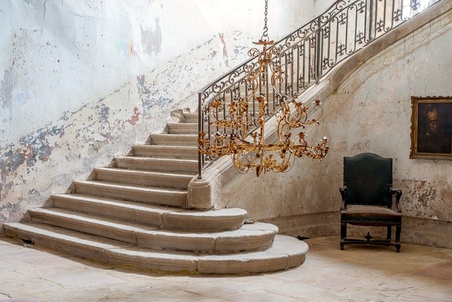 Stripped walls and stone staircase in foyer of French Chateau Gudanes