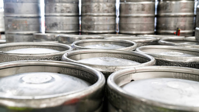 rows and stacks of silver beer kegs