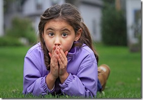 Surprised child laying in the grass