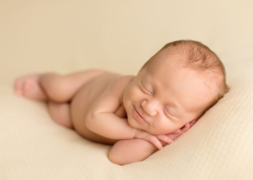 the photographer catches the smiles of sleeping babies