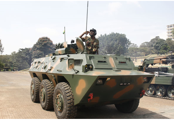 Kenya army APC vehicle passes by a tank