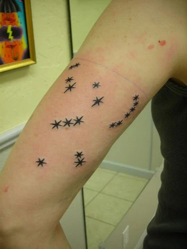 chica con tatuaje de la constelación de orion en la parte posterior del brazo