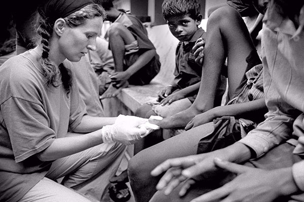 Una voluntaria atiende a unos niños en la India.