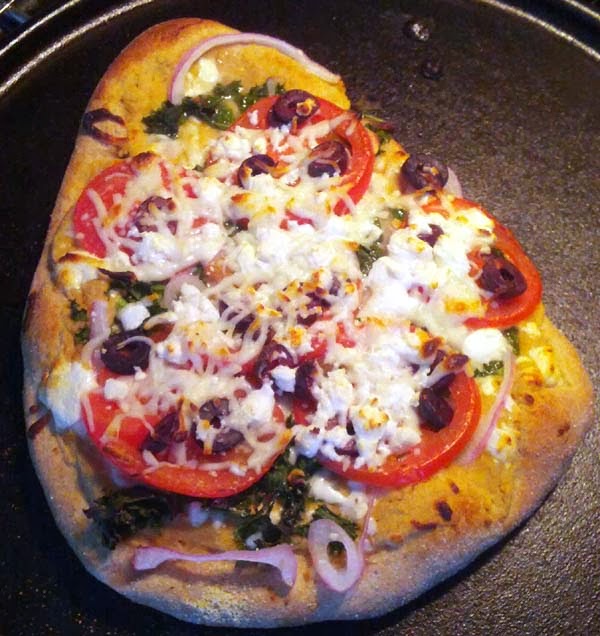 Vegetarian Pizza w/ Garlic Hummus as Sauce topped w/ Onions, Tomatoes, Kale, Olives, Feta Cheese, and Mozzarella. Lots of Mozzarella! Homemade Crust, too.