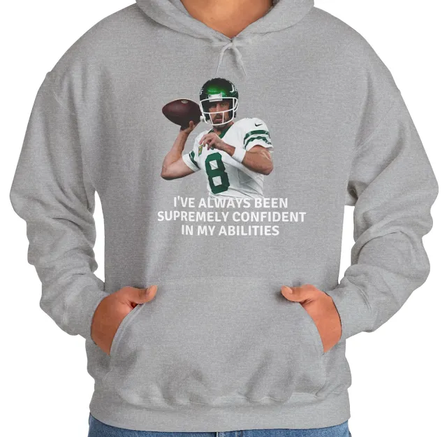 A Hoodie With NFL Player Aaron Rodgers Holding the Duke In Right Hand Ready to Throw Ball and Quote