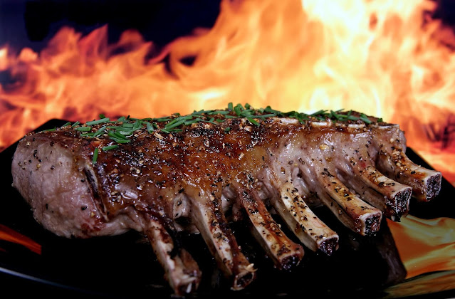 Ribs on a flaming hot grill.