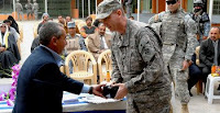 Muzhir Ali Salman, General Cooperative Union chairman, presents a souvenir to Army Col. Ted Martin during the Saydiyah Fish Market's ribbon-cutting ceremony in southern Baghdad, Feb. 9.