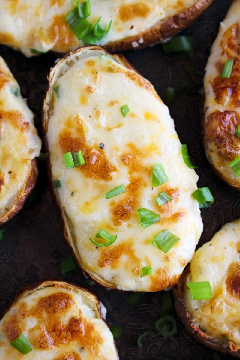 Top view closeup of Air Fryer Twice Baked Potatoes on a grey plate.