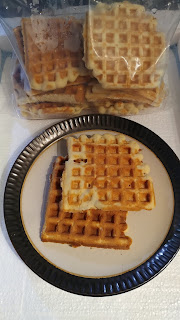 A round plate holds two delicious-looking waffles, next to a zip-lock bag full of more of the same