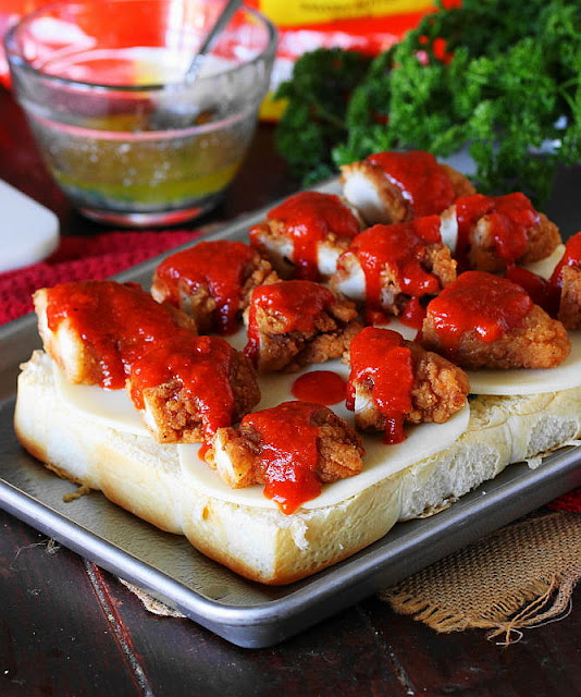 Making Chicken Parmesan Sliders - Chicken Tender Pieces Topped with Marinara Sauce Image