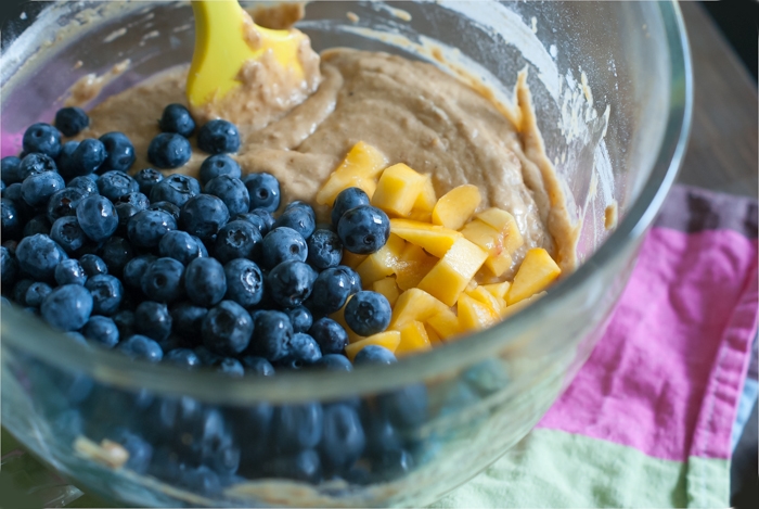 peaches and blueberries in mixing bowl, making fruit muffins