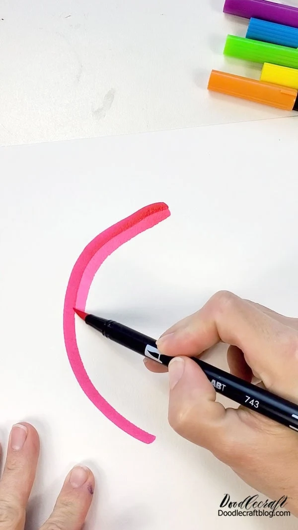 Then start with the first marker and draw a curved arch on the watercolor paper. Then follow the arch with the second marker color.