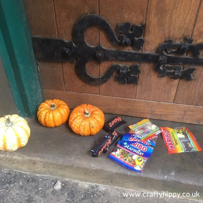 Halloween sweets and pumpkins on the doorstep of a wooden door