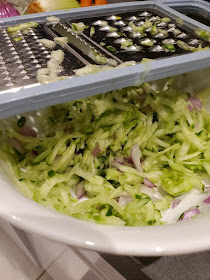 hand grater with grated cucumber salad