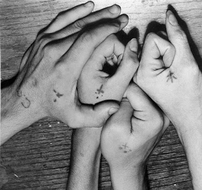 Tiny cross tattoos on hands.