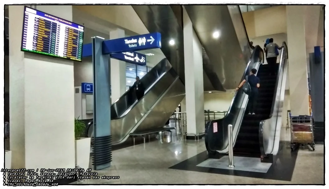 Pictures of electronic notice boards displaying bus departure schedules. Look at the escalator to the KLIA Terminal.