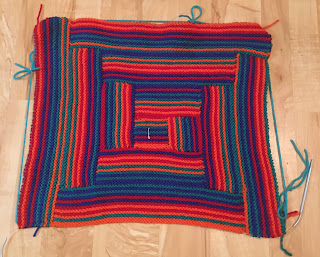 A large rectangle made of smaller striped rectangles arranged around a striped square. The layout is similar to log cabin quilt blocks.