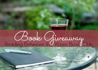 Maroon banner through the middle with the words: Book Giveaway in scrolling white and below in smaller black letters: Reading Between the Wines Book Club. The slightly out of focus image behind is summertime greenery and a patio table with a notebook and pen.
